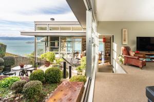 een huis met een balkon met uitzicht op de oceaan bij Roseneath Escape - Panoramic Harbour Views in Wellington