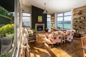 een woonkamer met een bank en een open haard bij Roseneath Escape - Panoramic Harbour Views in Wellington +6 foto's