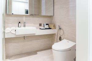 a bathroom with a white toilet and a sink at The First Clark Hotel and Residence in Pampang +41 photos