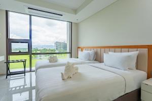 PampangThe First Clark Hotel and Residence的在酒店房间设有两张床,里面装满了动物