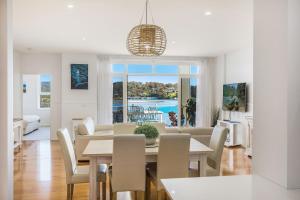 a dining room and living room with a table and chairs at Wharf Apartment Unit 5 in Narooma