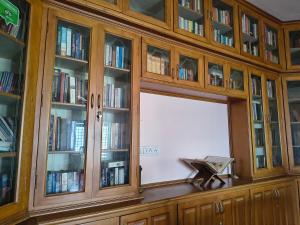 a large wooden cabinet with a window filled with books at Karithanam Ayur Farms in Vaikom