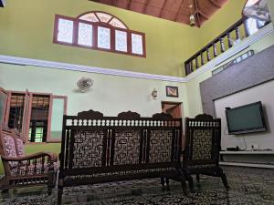 a living room with two chairs and a television at Karithanam Ayur Farms in Vaikom