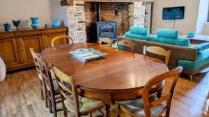 a living room with a wooden table and a couch at Belle vue in Dournazac