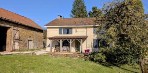 a large white house with a porch in a yard at Belle vue in Dournazac