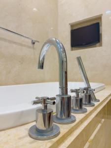 - un lavabo avec trois robinets sur un comptoir dans l'établissement Straits Quay By The Marina 1BR Family Suite, à Tanjong Tokong