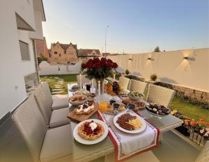 a table with breakfast food on a balcony at Villa Lumiere-Luxury Retreat with Private Spa and Garden in Ifrane