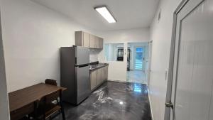 a kitchen with a refrigerator and a table in it at RiverHouse Luquillo in Ramos