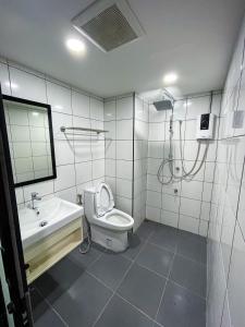 Un baño con inodoro, lavabo y ducha. en The 2nd Floor, en Lampang