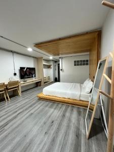 Un dormitorio con una cama y un televisor de pantalla plana. en The 2nd Floor, en Lampang