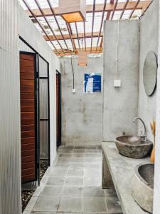 a bathroom with a stone sink and a sink at PukuPods - Tent & Cabin in Tabanan