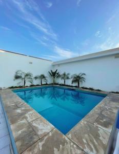 a swimming pool in a building with palm trees at Casa de Playa en Lobos in Cerro Azul