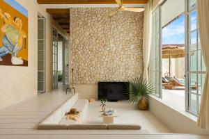 a living room with a couch and a fireplace at Sonata Koh Samui in Koh Samui 