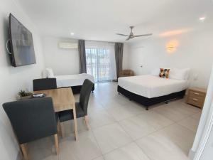 1 dormitorio con 2 camas, mesa y comedor en Best Western Ambassador Motor Lodge, en Hervey Bay