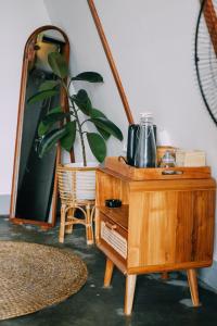 a wooden dresser with a mirror and a potted plant at PukuPods - Tent & Cabin in Tabanan