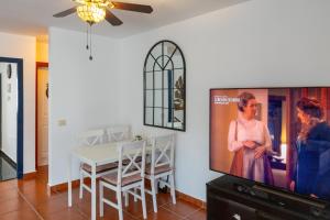a dining room with a tv and a table at Sweet Home Botanico in Adeje