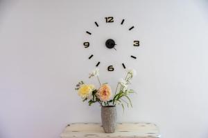 a vase with flowers and a clock on a wall at Sweet Home Botanico in Adeje +70 photos