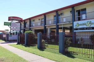 a building with a fence next to a street at Spanish Lace Motor Inn in Townsville