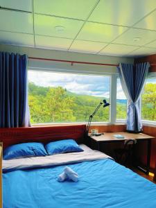 una camera con letto e finestra su una barca di Sill Dalat Homestay a Ấp Ða Lợi