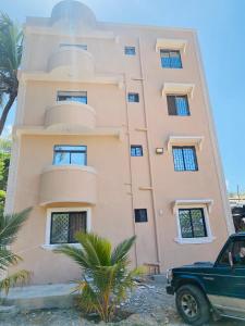 ein Gebäude mit einem LKW, der davor parkt in der Unterkunft Casa Bellah Sunrise in Watamu