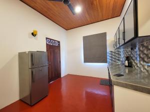 a kitchen with a refrigerator and a counter top at Sithujaya Green Mirissa in Mirissa