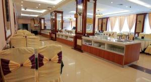 麗江市にあるGolden Spring Hotel Lijiangのカウンターのある店内に空の椅子が置かれたサロン