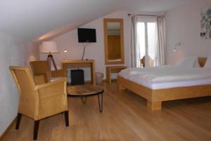 ein Schlafzimmer mit einem Bett, einem Tisch und einem Stuhl in der Unterkunft Hotel Bad Schwarzsee in Bad-Schwarzsee