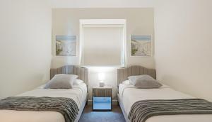two twin beds in a room with a window at Blue Harbour Amazing views 5 min downtown in Fort Myers +28 photos