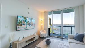a living room with a tv and a large window at Blue Harbour Amazing views 5 min downtown in Fort Myers