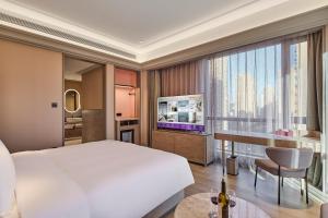 a bedroom with a large bed and a television at Mercure Xi'an Chanba in Xi'an +15 photos