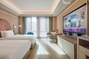 a hotel room with a bed and a flat screen tv at Mercure Xi'an Chanba in Xi'an