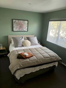 a bedroom with a large bed with a window at Wheatstone Hideaway in Gisborne