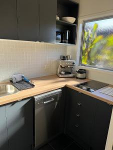 a small kitchen with a sink and a counter top at Wheatstone Hideaway in Gisborne +5 photos