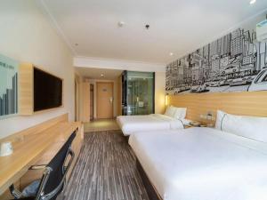 a hotel room with two beds and a television at City Comfort Inn Zhongshan Lihe Square Walmart Branch in Zhongshan +248 photos