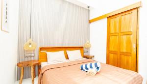 - une chambre avec un lit et une porte en bois dans l'établissement Arrum Villa Ungasan, à Ungasan