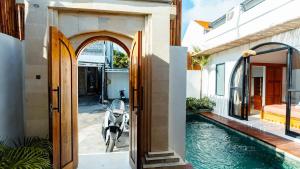 une porte ouverte sur une maison avec piscine dans l'établissement Arrum Villa Ungasan, à Ungasan