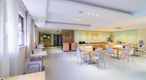 a cafeteria with tables and chairs in a building at City Comfort Inn Zhongshan Lihe Square Walmart Branch in Zhongshan