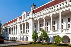 a large white building with a red roof at Classic Hotel in Jakarta