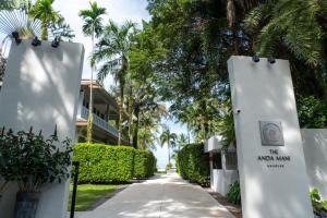 a walkway in front of a house with palm trees at The Anda Mani Khaolak Beachfront Villas in Khao Lak