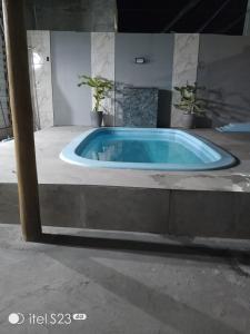 a jacuzzi tub in the middle of a building at Casa com piscina e área gourmet em Arembepe in Camaçari