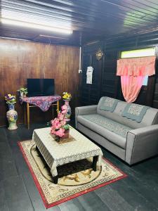 una sala de estar con un sofá y una mesa en Rumah Kayu Homestay, en Bedung