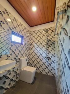 a bathroom with a toilet and a sink at Sithujaya Green Mirissa in Mirissa