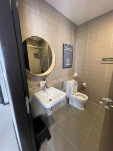 une salle de bain avec un lavabo, des toilettes et un miroir dans l'établissement D Pristine 3 bedroom Apartment opp to Legoland, à Iskandar Puteri