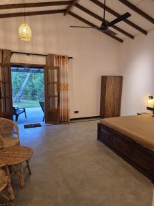 a bedroom with a bed and a table and chairs at the cinnamon home in Koggala