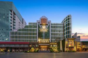 Un gran edificio con una torre de reloj en la parte superior. en Jinjiang Metropolo Zhengzhou Songshan Road, en Zhengzhou