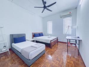 a bedroom with two beds and a ceiling fan at Tanjung Bungah Holiday Home 4BR 20Pax 6Carpark in Tanjung Bungah +65 photos