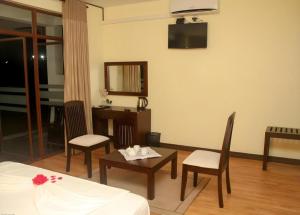 a hotel room with a bed and a table and chairs at Talawakele Rest House in Talawakele