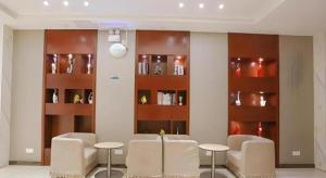a dining room with chairs and tables and shelves at City Comfort Inn Wuhan Zhongnan Hospital Shuiguohu Metro Station in Wuhan