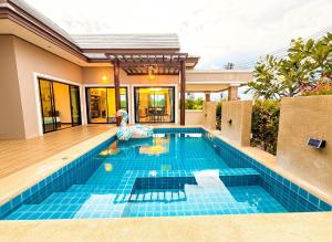 a swimming pool in the backyard of a house at Pran Suk Pool Villa pranburi 