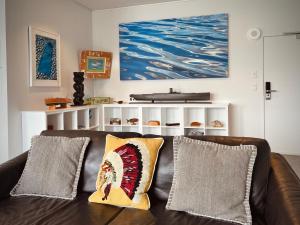 a couch with two pillows on it in a living room at Luxury Waterfront Marina Apartment - Bay of Islands, New Zealand in Opua